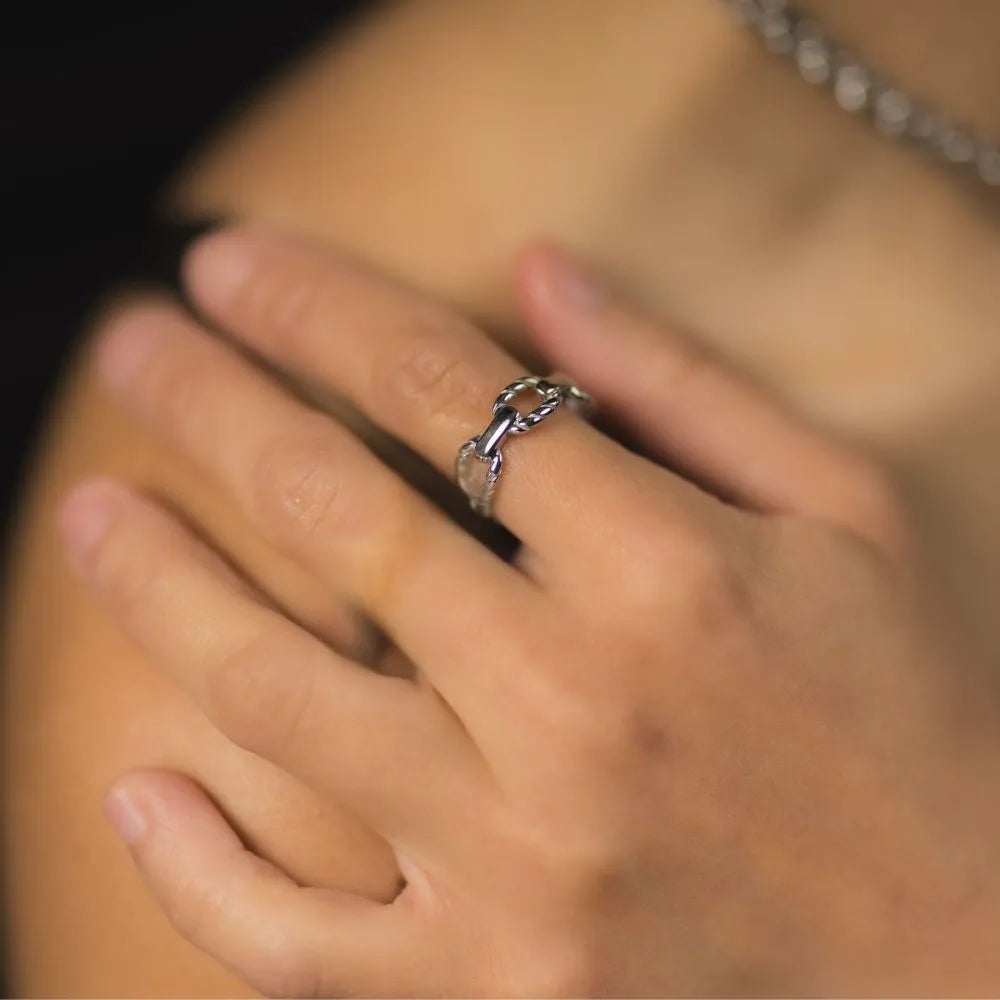 Hand resting in shoulder wearing chunky anchor-inspired ring – expressing strength, connection, and bold minimalism.