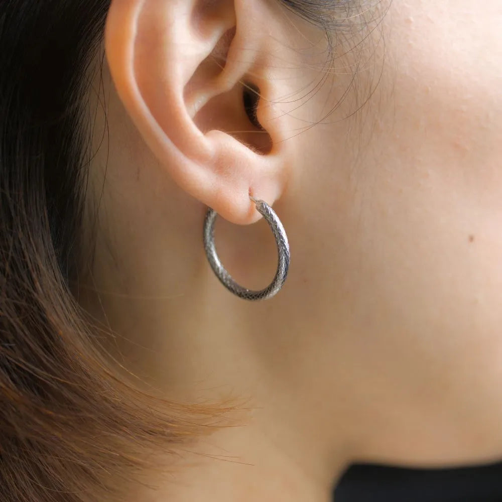 Subtle hoop earrings with coiled texture – balancing dimension and elegance.