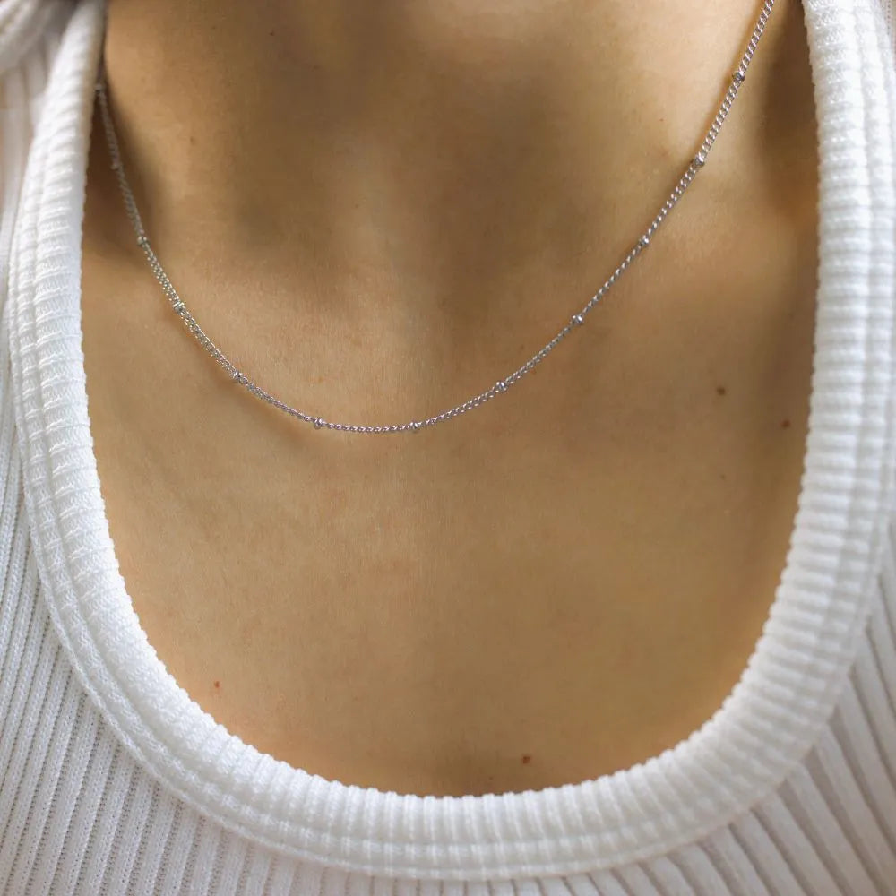 Fine arc necklace with subtle texture – inspired by natural contours and soft resilience.