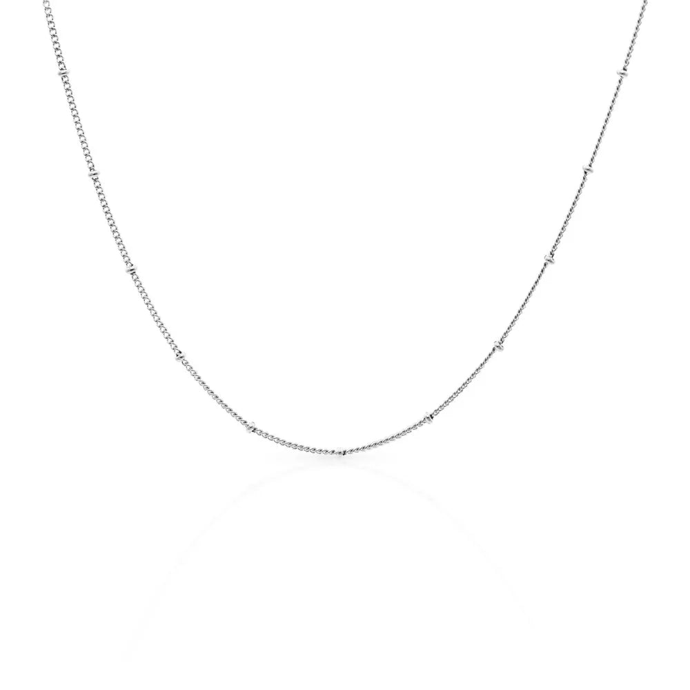 Fine arc necklace with subtle texture – inspired by natural contours and soft resilience.