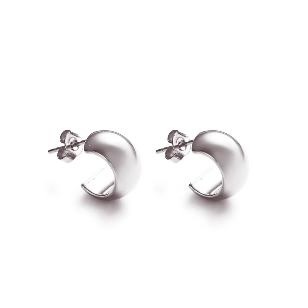Curved silver stud earrings – a bold, minimal expression of presence and form.