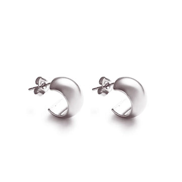Curved silver stud earrings – a bold, minimal expression of presence and form.