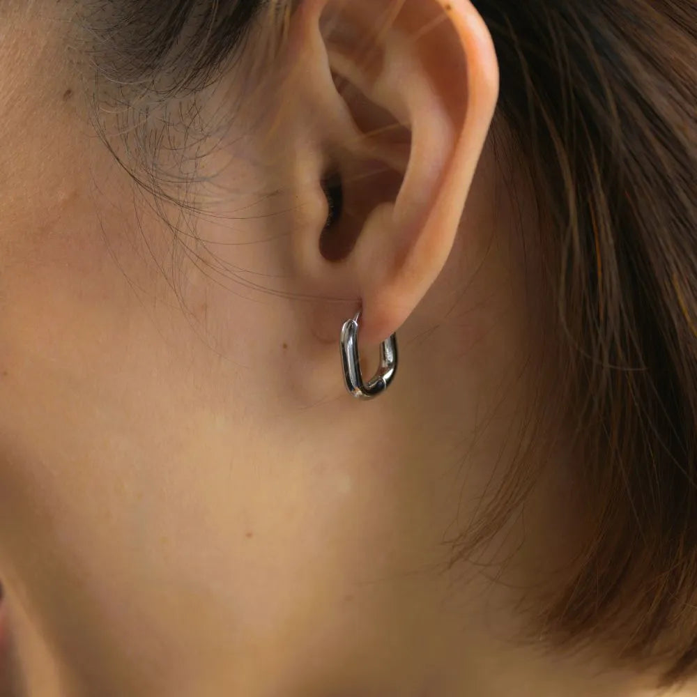 Model wearing geometric ellipse hoops – highlighting ease, symmetry, and daily movement.