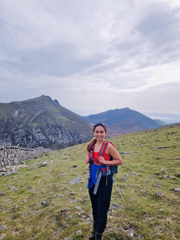 EQUØRA founder hiking in the mountains, wearing minimalist jewellery and a red top – reflecting strength, clarity, and the brand’s movement-ready ethos in nature.