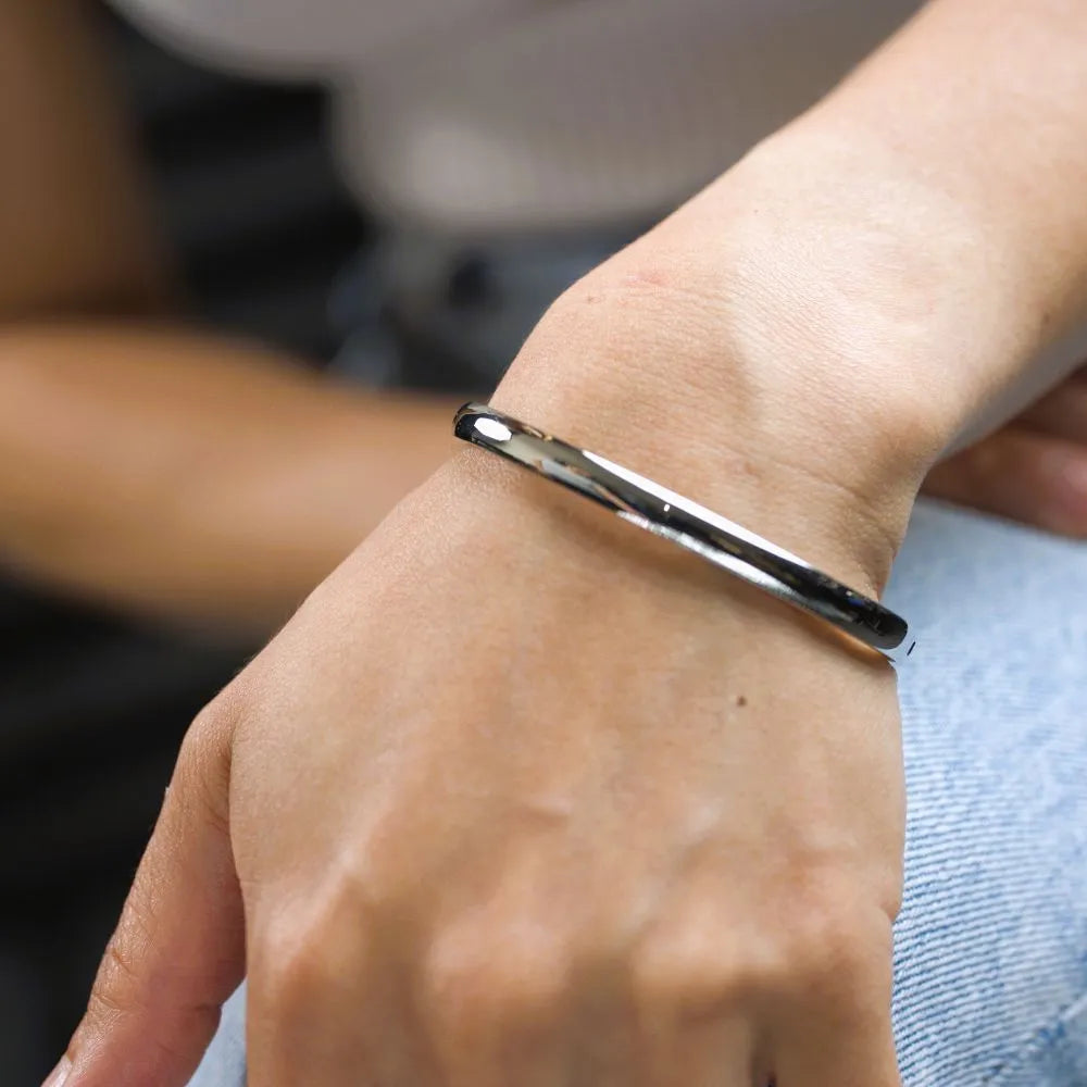 Minimalist silver bangle bracelet with a sleek, smooth finish – designed for movement, simplicity, and refined strength.