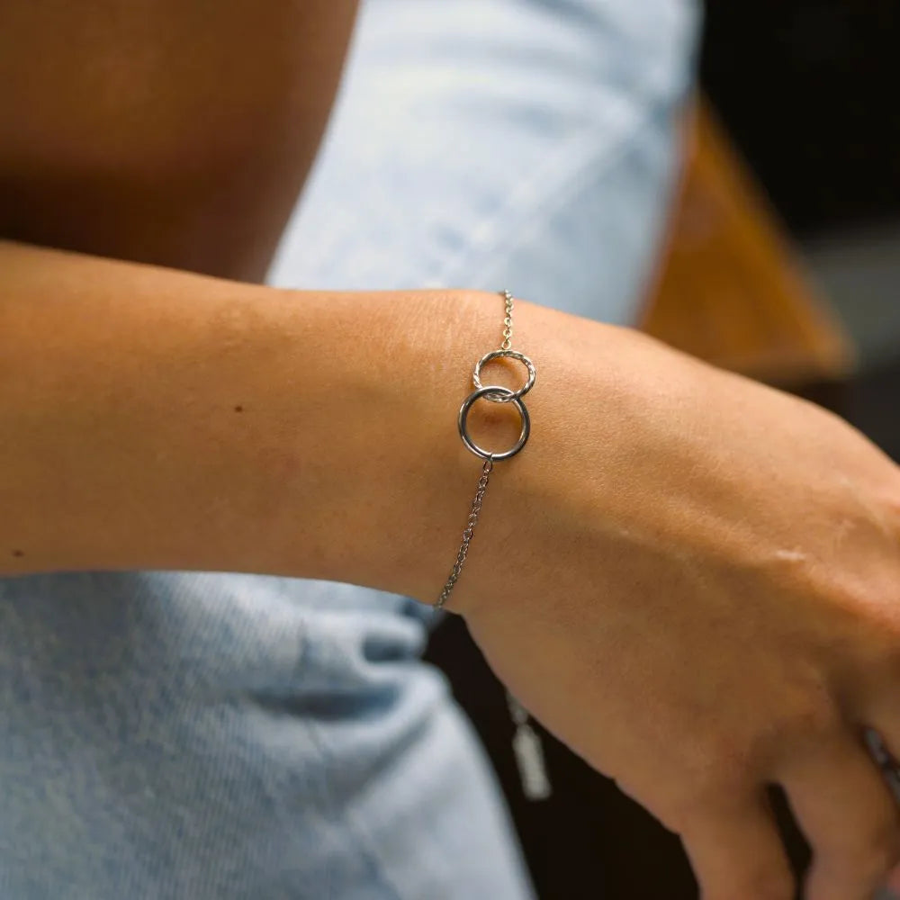 Model wearing a fine infinity chain bracelet – expressing harmony, softness, and the resilience of connection.