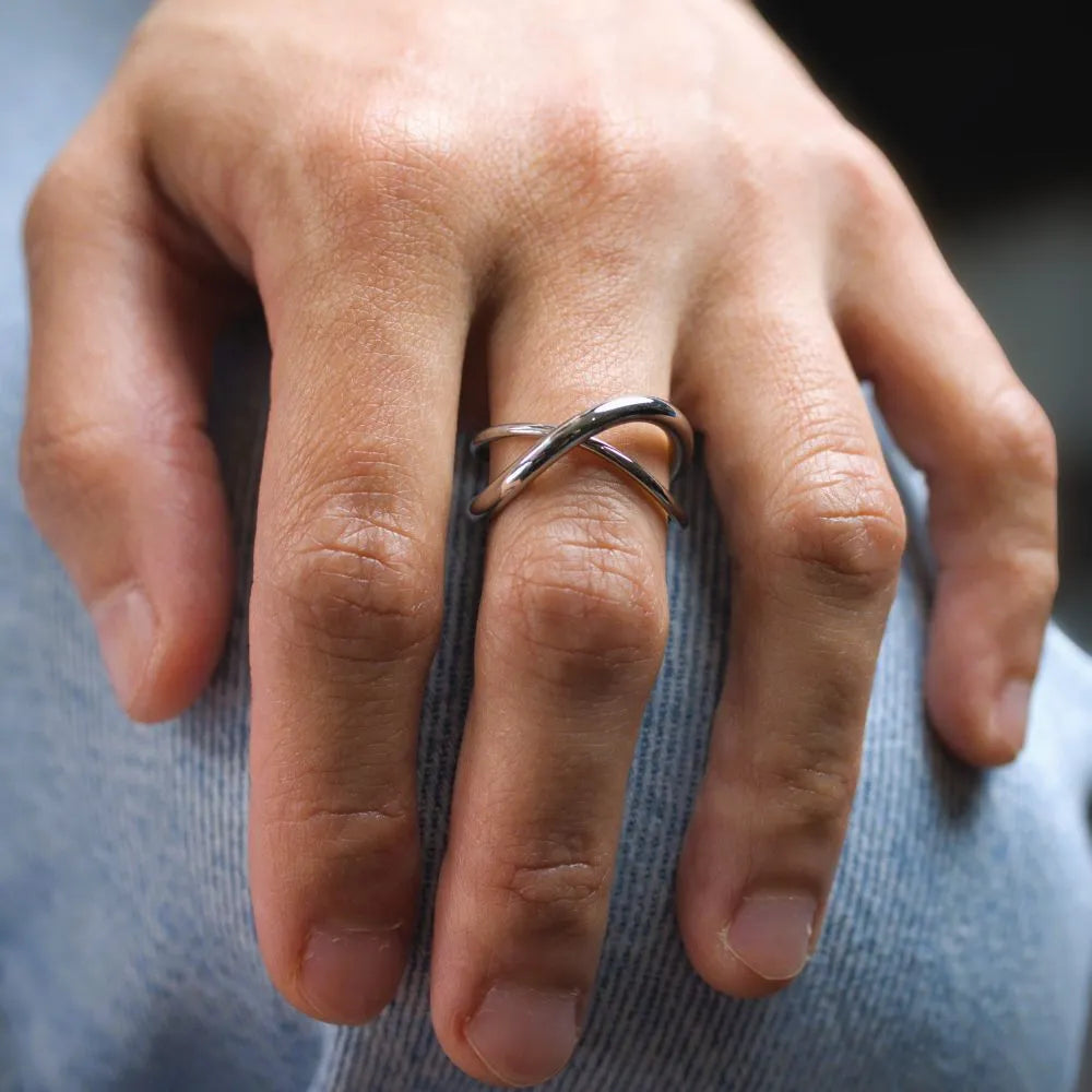 Minimal silver stacking rings intertwined – offering versatile styling and quiet balance.