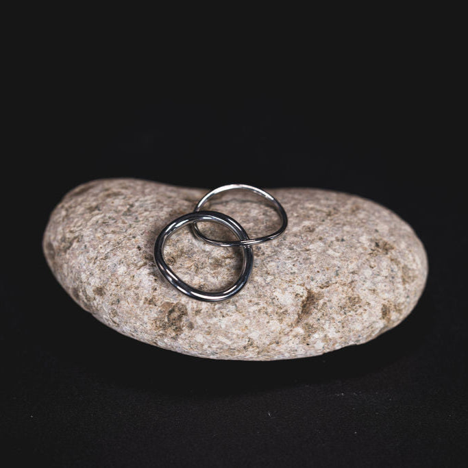 EQUØRA Linea Stack Rings — sleek and minimal stainless steel rings with a smooth polished finish, stacked on a neutral stone for a timeless, modern look. Perfect for everyday wear.