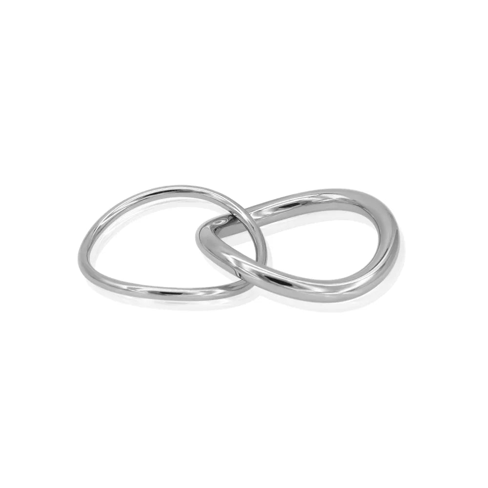 Minimal silver stacking rings intertwined – offering versatile styling and quiet balance.