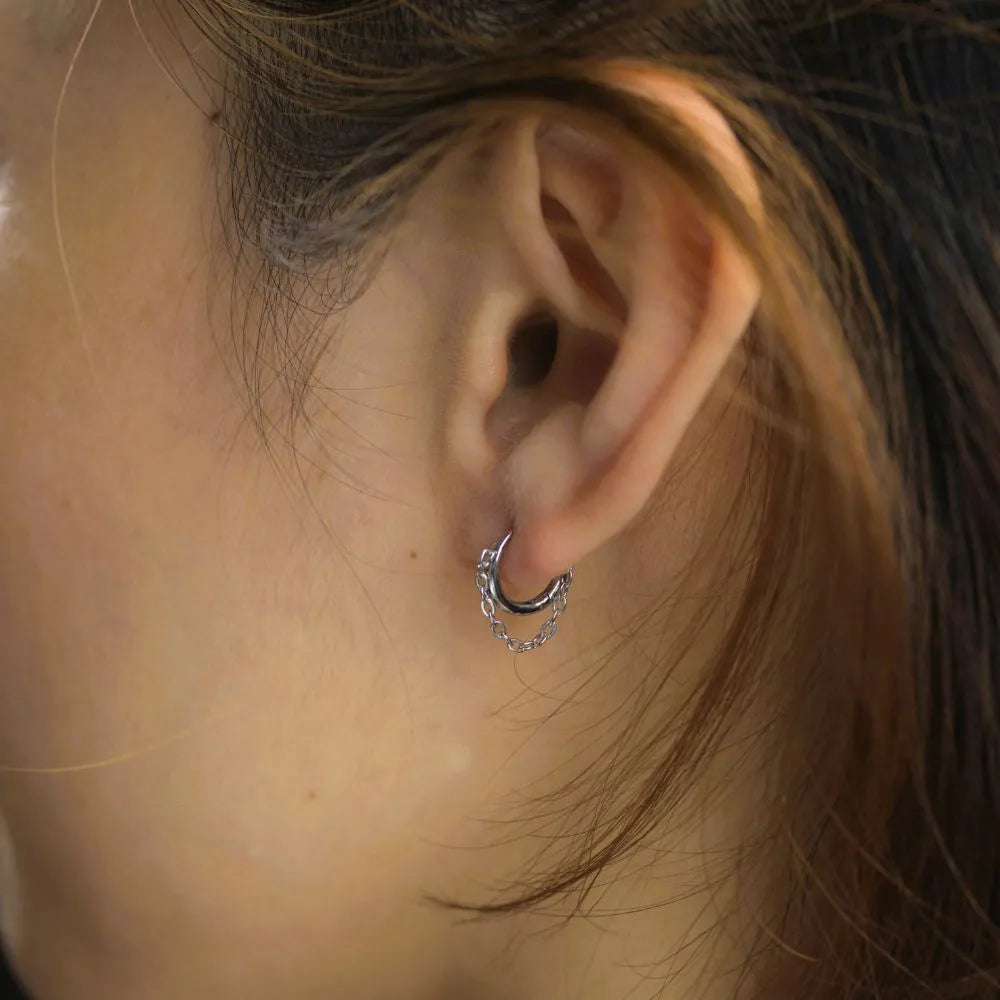 Hoop earrings with chain-link detail – embodying modern structure and fluid strength.