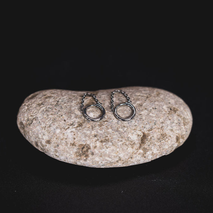 EQUØRA Link Earrings featuring a double-looped drop design in polished stainless steel, resting on a smooth stone — minimalist, nickel-free, and designed for all-day comfort.