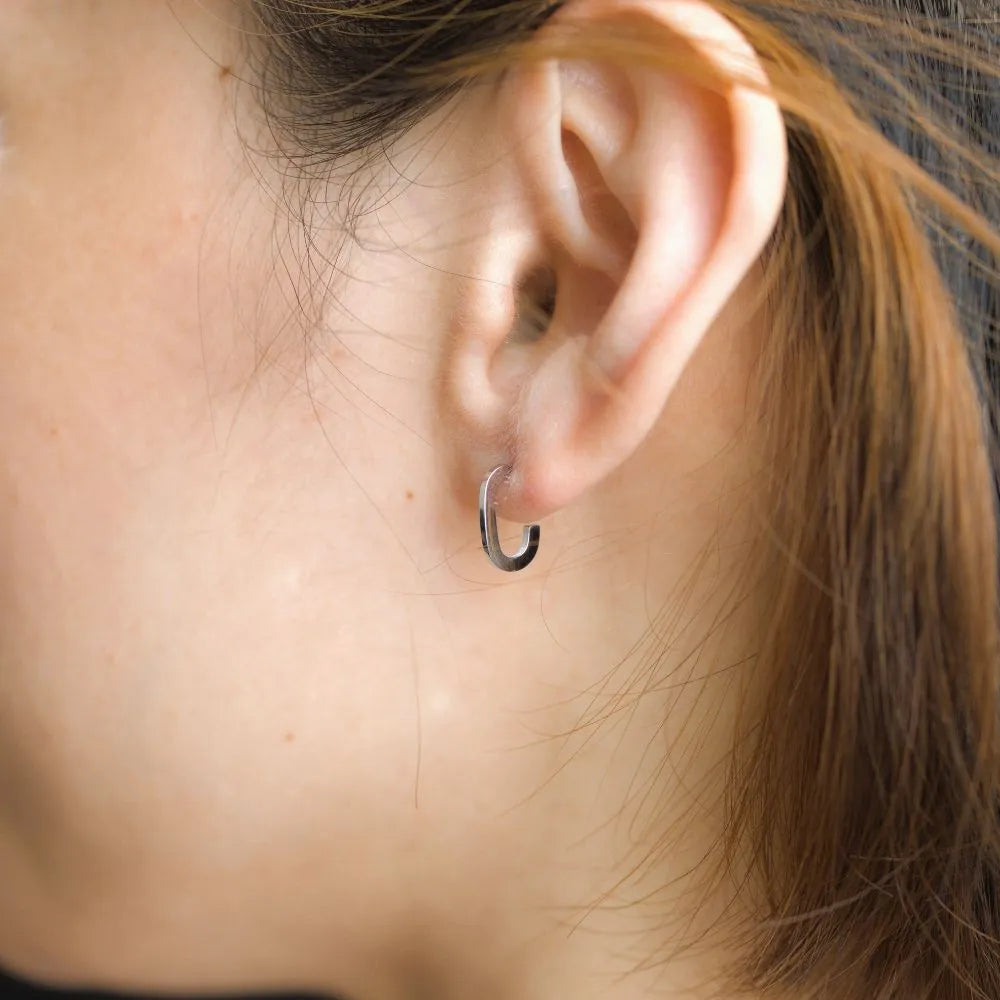 Small open-ended hoop studs – wearable balance of edge and elegance.