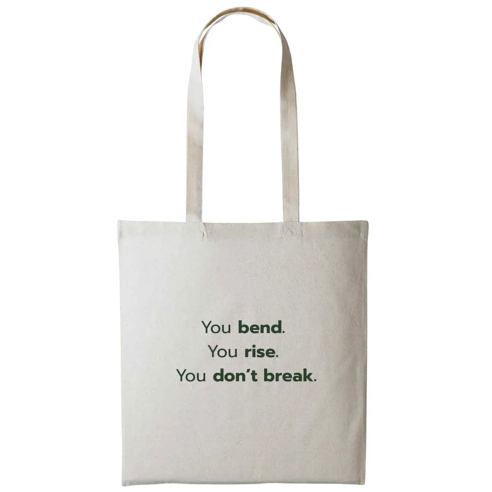 Back of canvas tote bag featuring the motivational text: "You bend. You rise. You don't break."