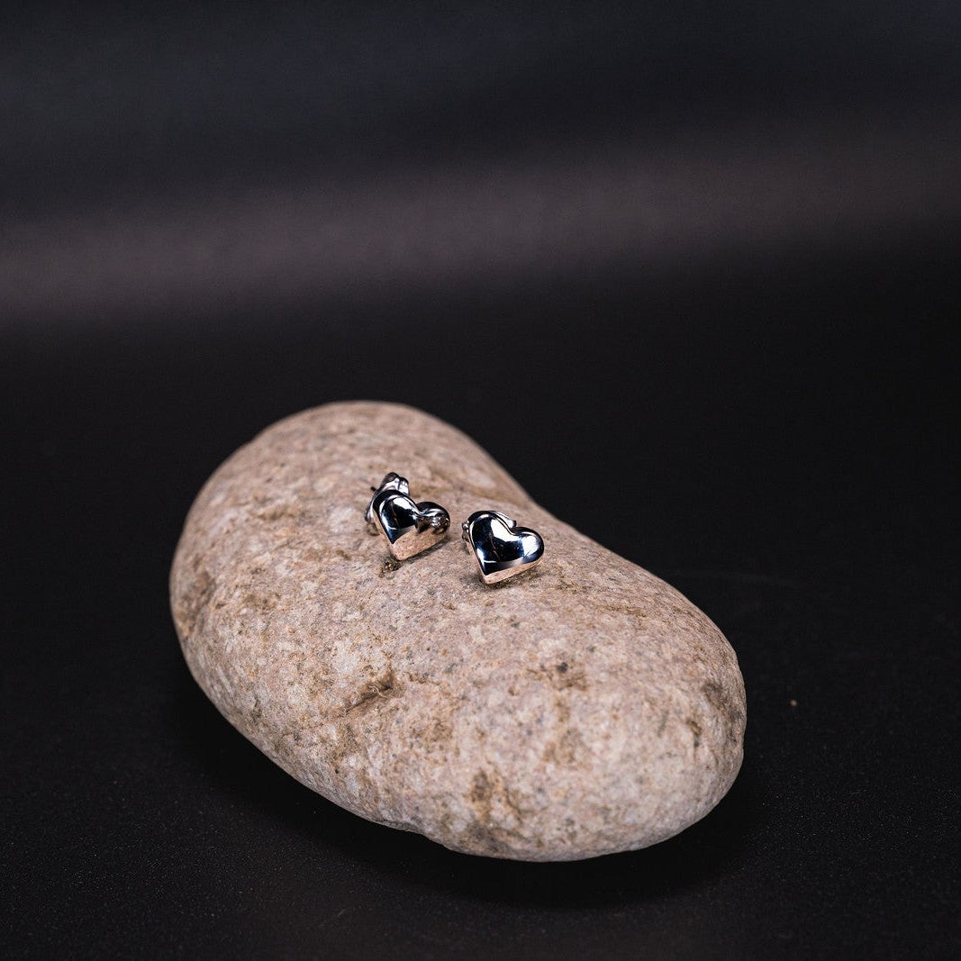 EQUØRA Vive Earrings — geometric rectangular stud earrings in stainless steel, displayed on a smooth stone. Sleek, water-safe and tarnish-resistant modern jewellery design.